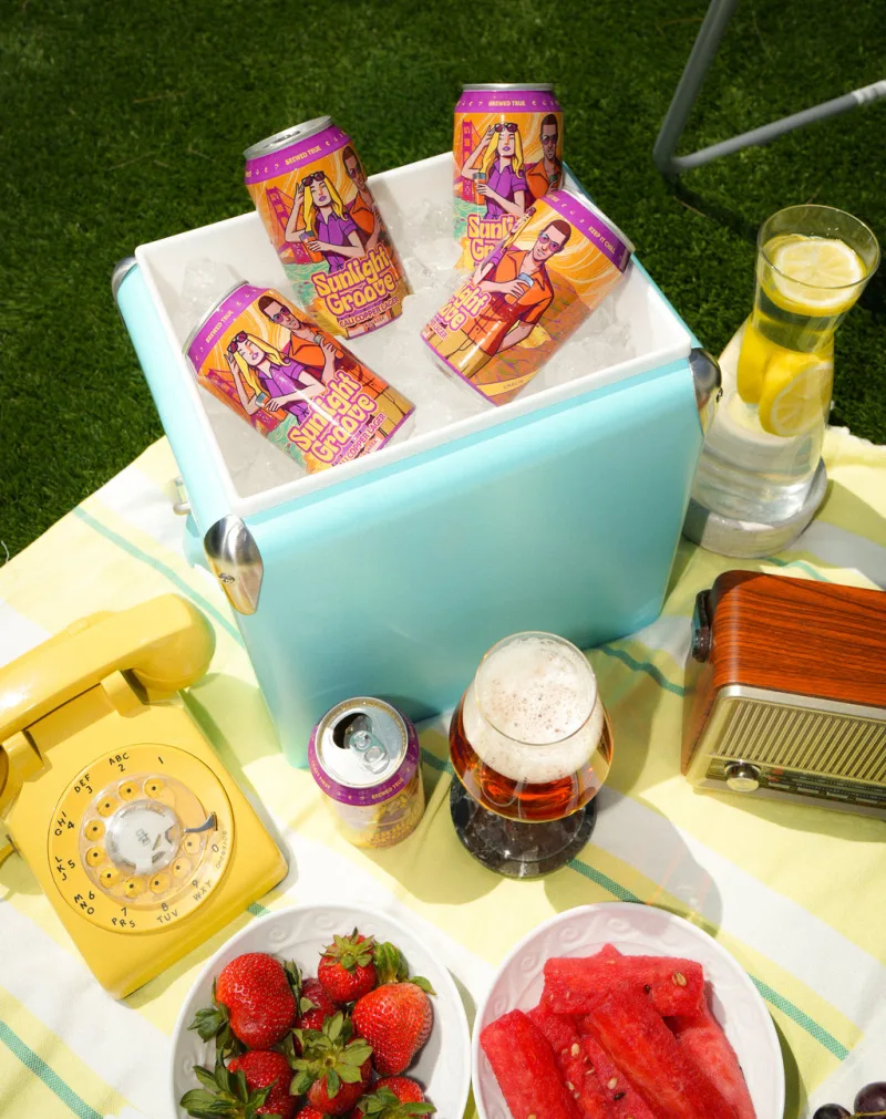 A picnic table set with cans and glasses